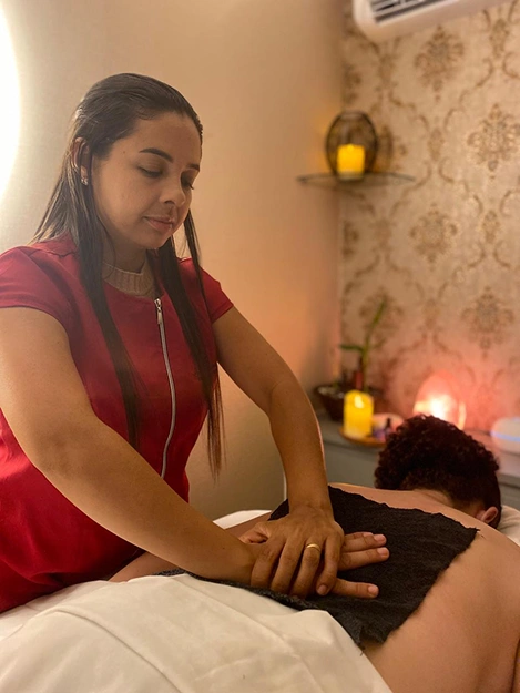 Massoterapeuta Liane fazendo massagem com uma toalha preta